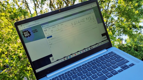Een open laptop met daarop een email tegen een achtergrond van bomen